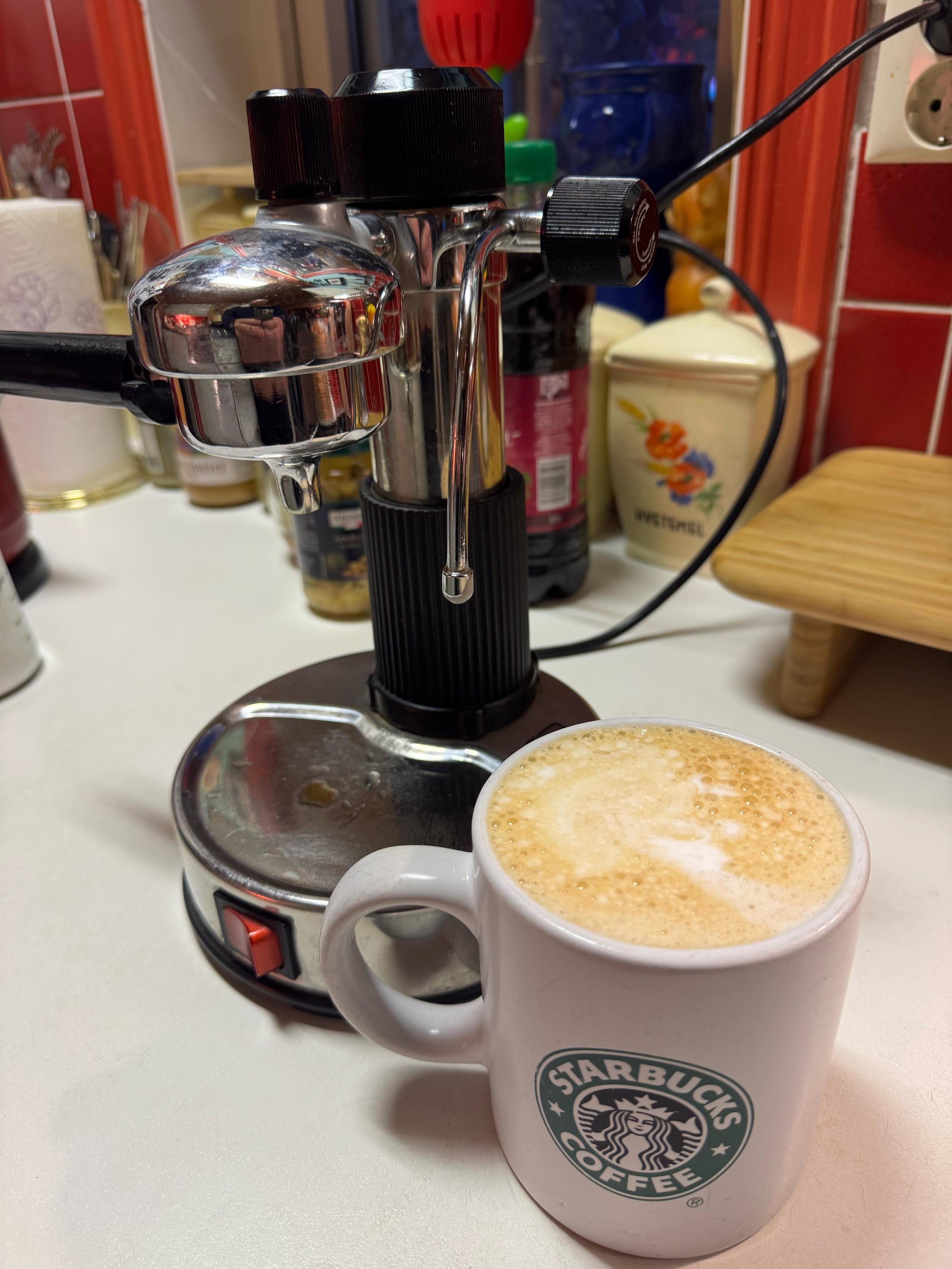 Chrome coffee brewer and the finished mug of latte