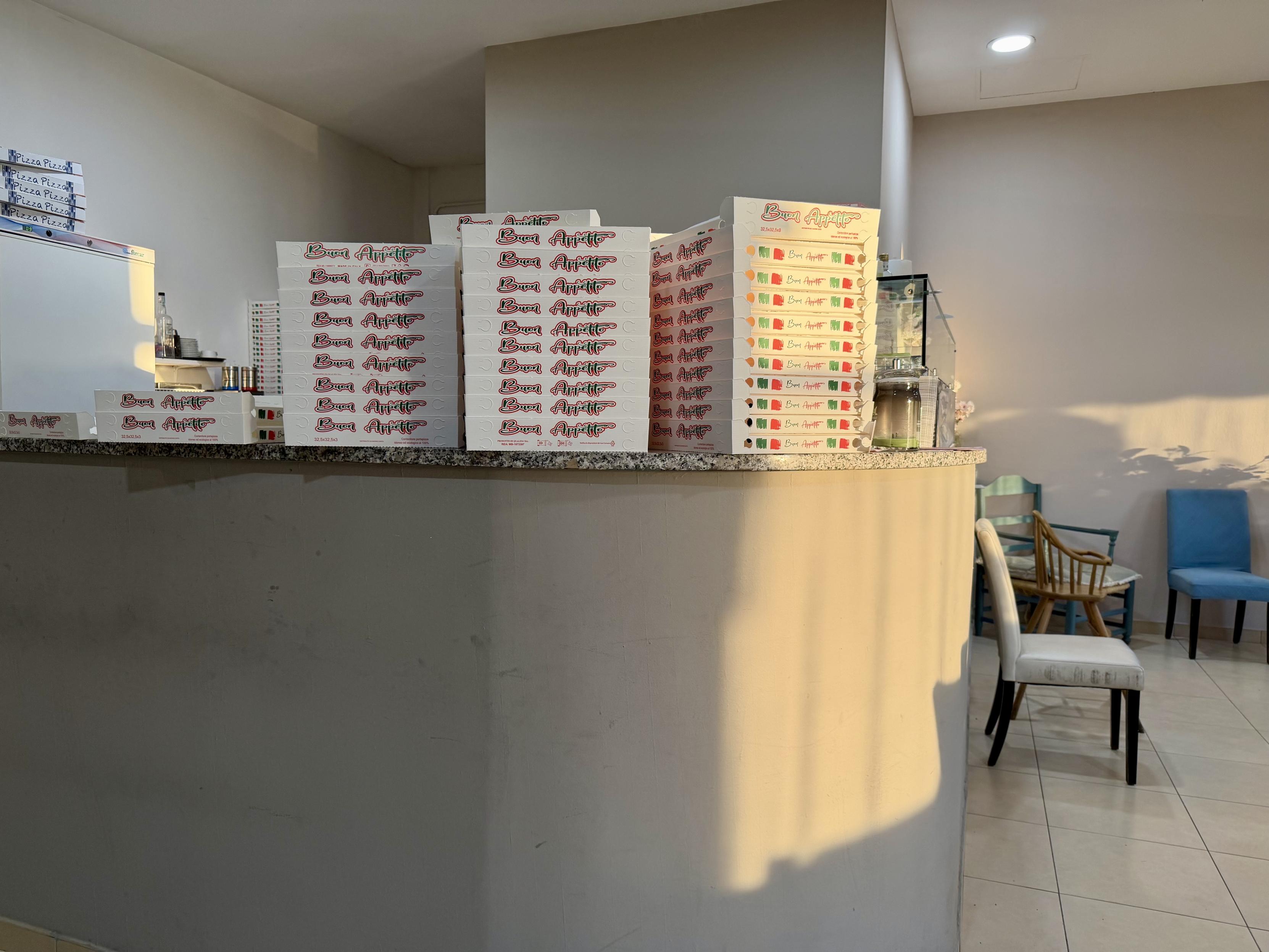 A bench, full of pizza boxes